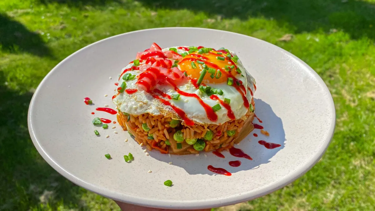 Ryż smażony z warzywami i jajkiem sadzonym, polany sosem. Idealny pomysł, z czym podawać kimchi, by stworzyć pyszne danie.