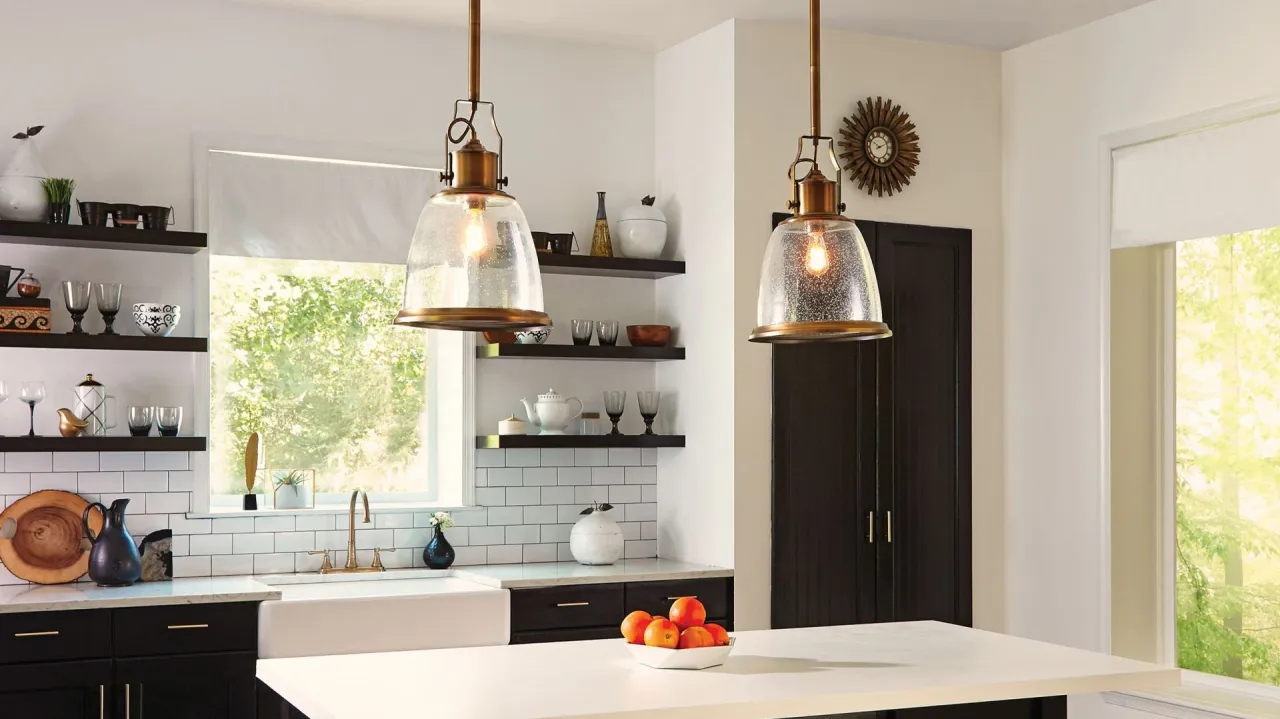 Dwa wiszące, mosiężne lampy z kloszami ze szkła bąbelkowego tworzą stylowe jakie oświetlenie nad wyspą kuchenną.