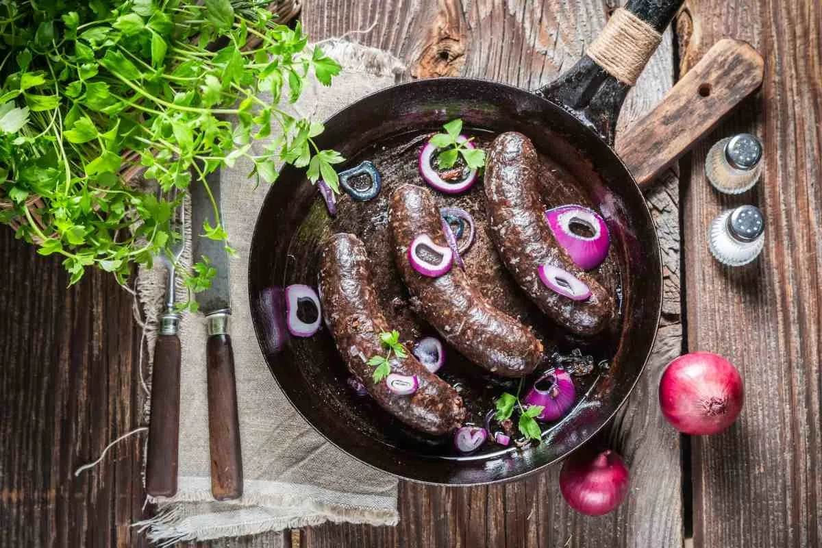 Smażona kaszanka z cebulą na patelni. Osoby z cukrzycą powinny spożywać ją z umiarem.