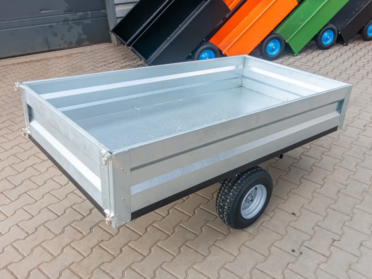 Solidna, galwanizowana przyczepka do traktorka, gotowa do transportu ziemi, liści czy narzędzi.