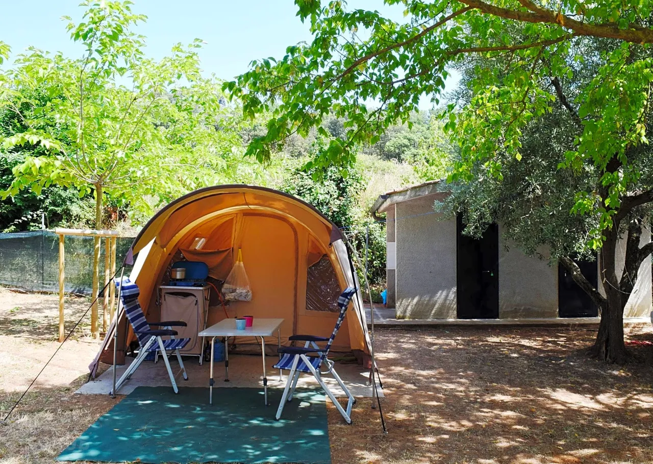 Namiot i krzesła pod drzewami, idealne na włochy spanie na dziko.