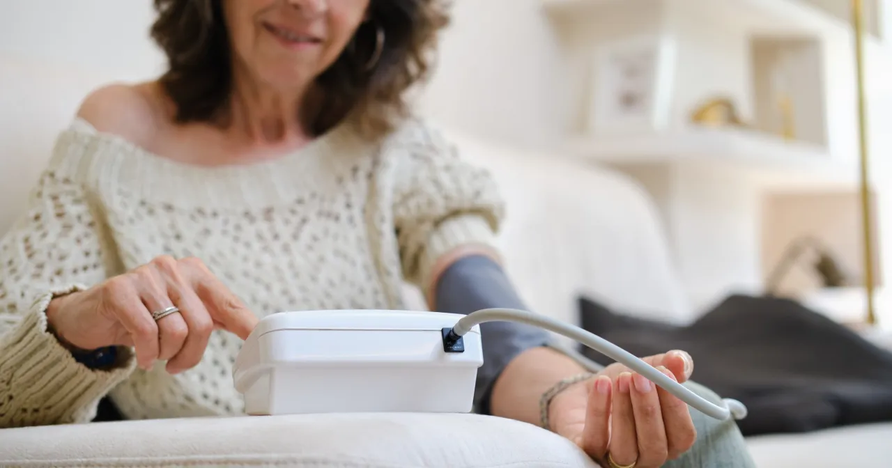 Starsza osoba mierzy ciśnienie, dbając o to, jak wzmocnić serce u starszej osoby.