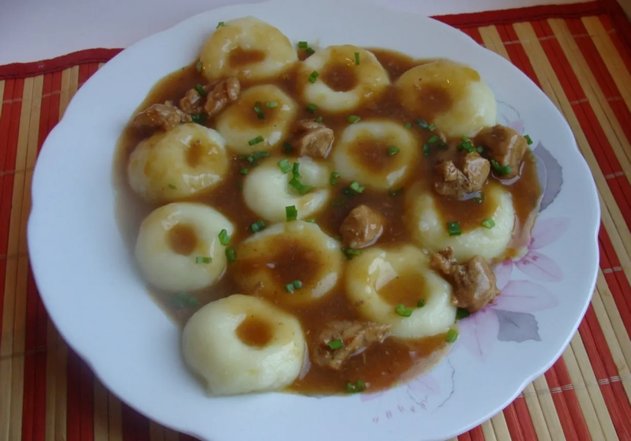 Kluski śląskie na talerzu z sosem