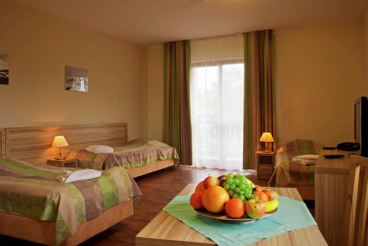 Pokój w Rabczańskim Zdroju. Opinie o sanatorium NFZ podkreślają komfortowe łóżka i świeże owoce.