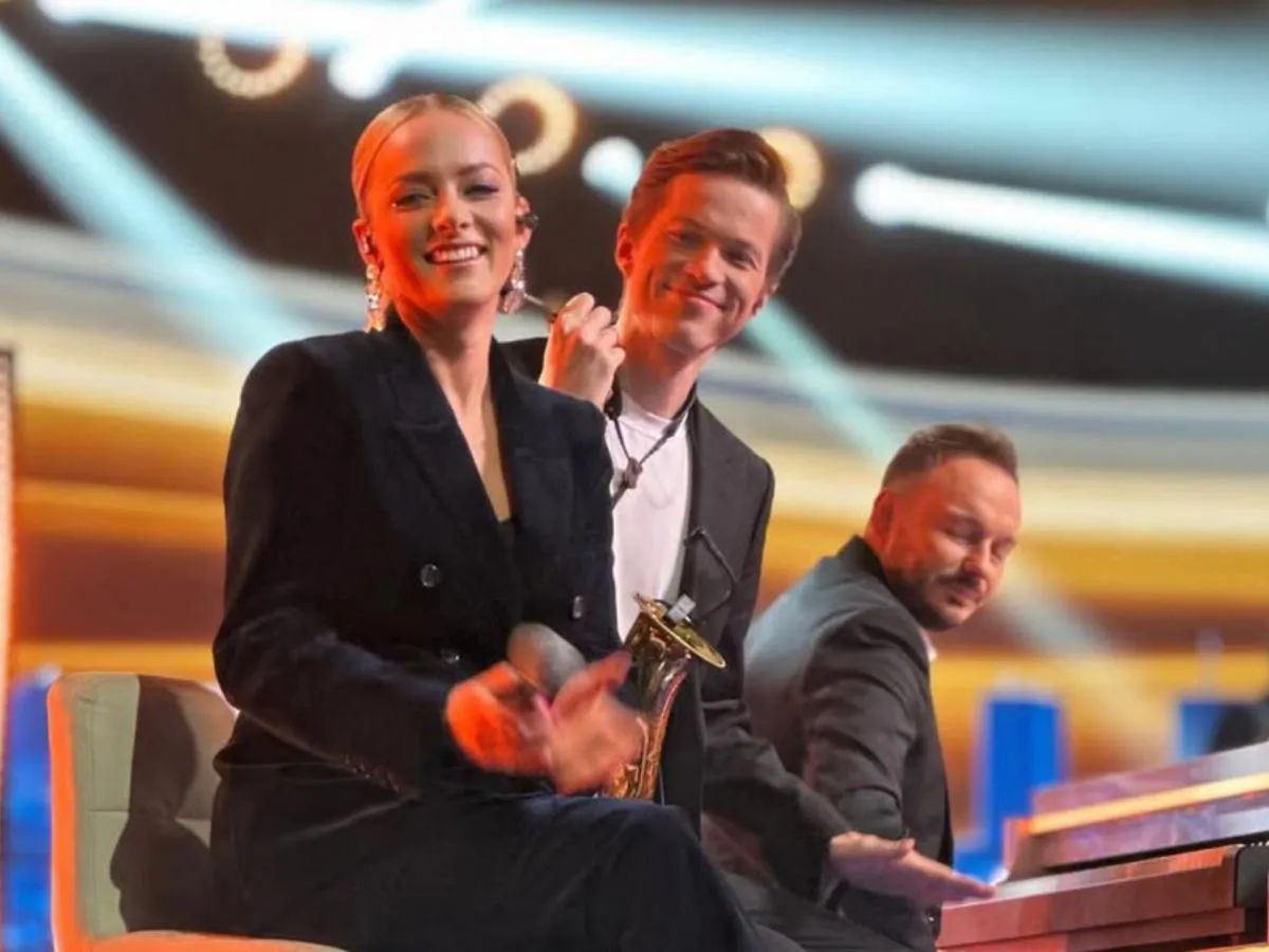 Uśmiechnięta piosenkarka z saksofonem i pianista na scenie. Jaka to melodia piosenkarze w akcji.