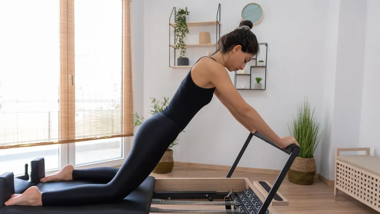 pilates na reformerze, kobieta ćwicząca na maszynie pilates