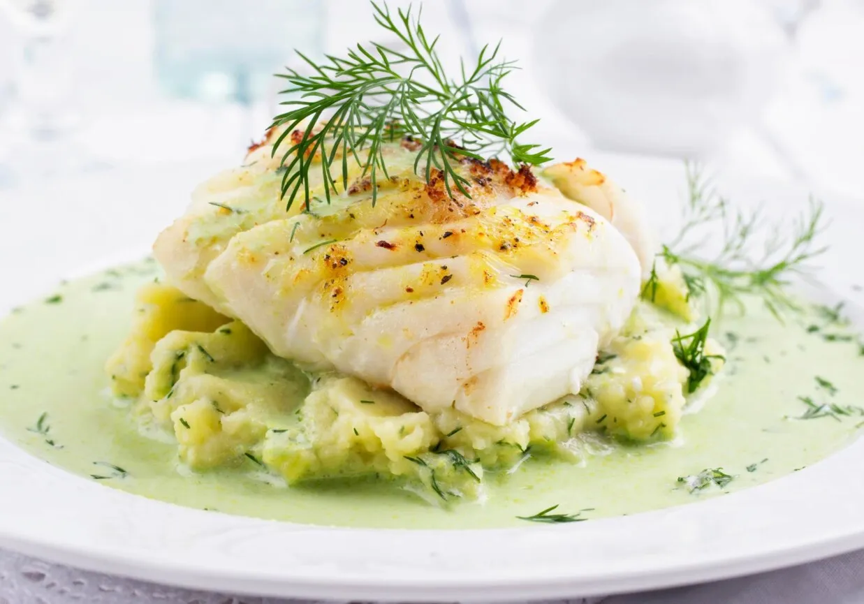 Pieczony filet rybny na purée ziemniaczanym z zielonym sosem. Idealne danie, które świetnie pasuje do ryby na obiad.