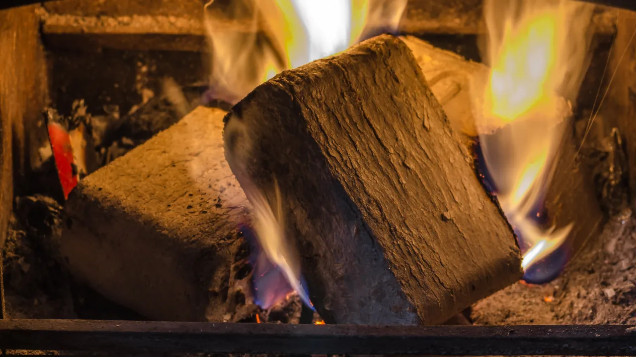 Dwa brykiety do kominka płoną w ogniu, tworząc ciepłą atmosferę.