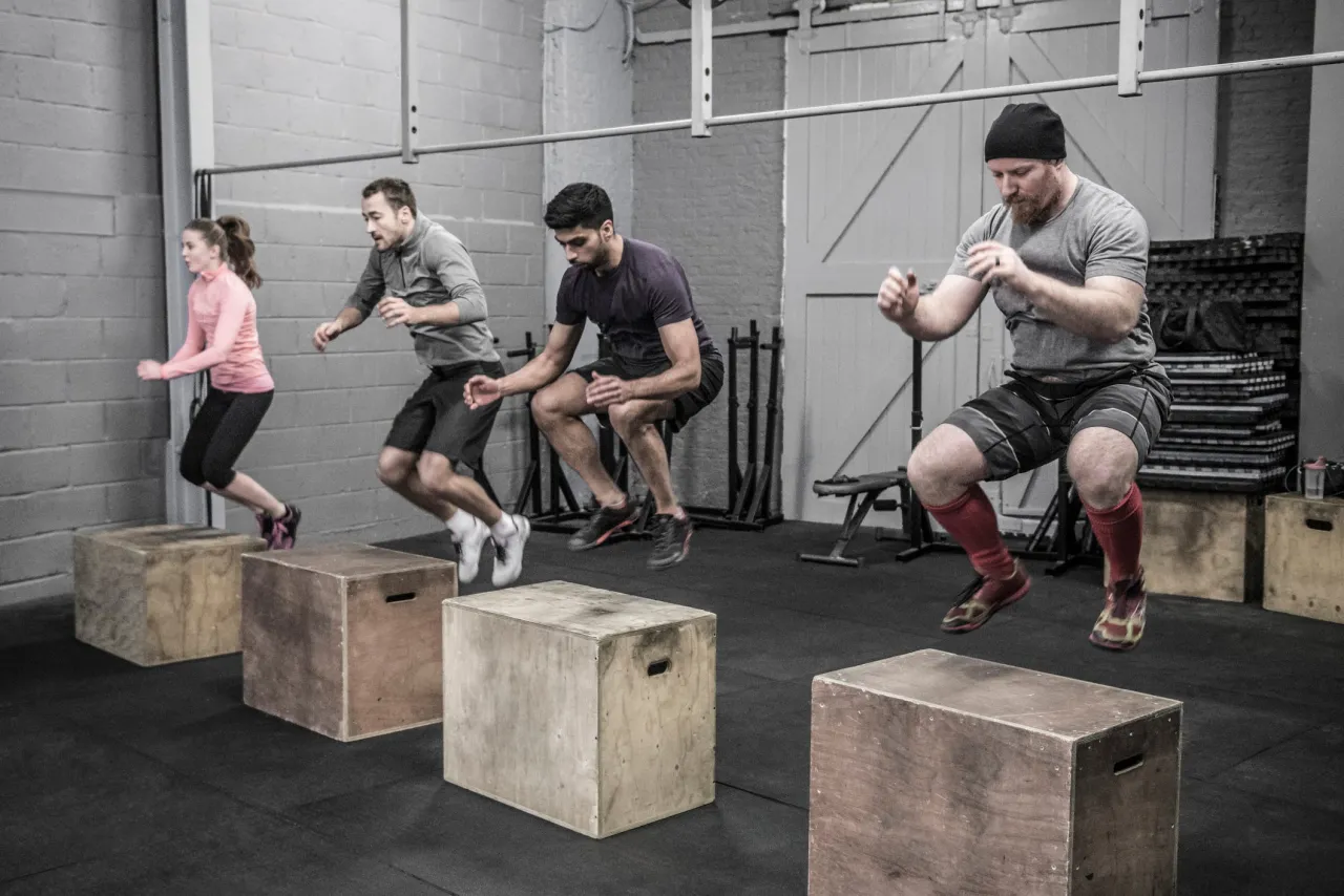 grupa ludzi trenująca crossfit w boxie