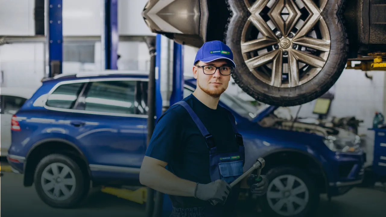 Mechanik samochodowy sprawdzający silnik lub opony