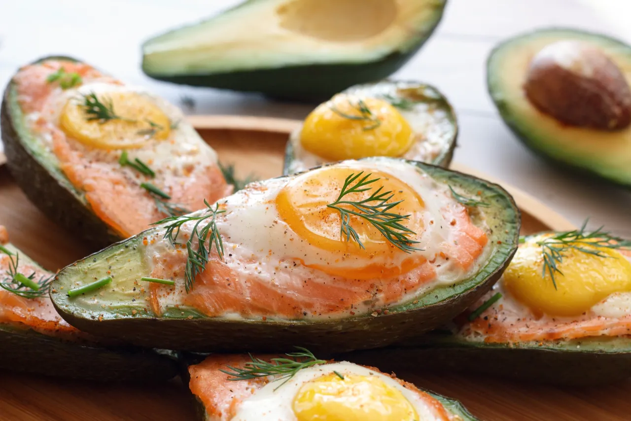 Poł&oacute;wki awokado z łososiem i jajkiem, zdrowe śniadanie, kt&oacute;re nie podnosi cholesterolu.