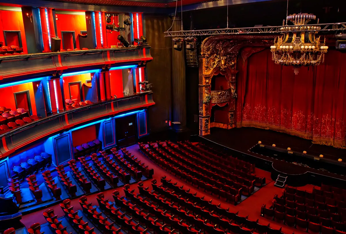 Wnętrze teatru z czerwonymi fotelami i złotym żyrandolem. Trudno oszacować, ile jest miejsc w teatrze Roma, ale jest ich mnóstwo!