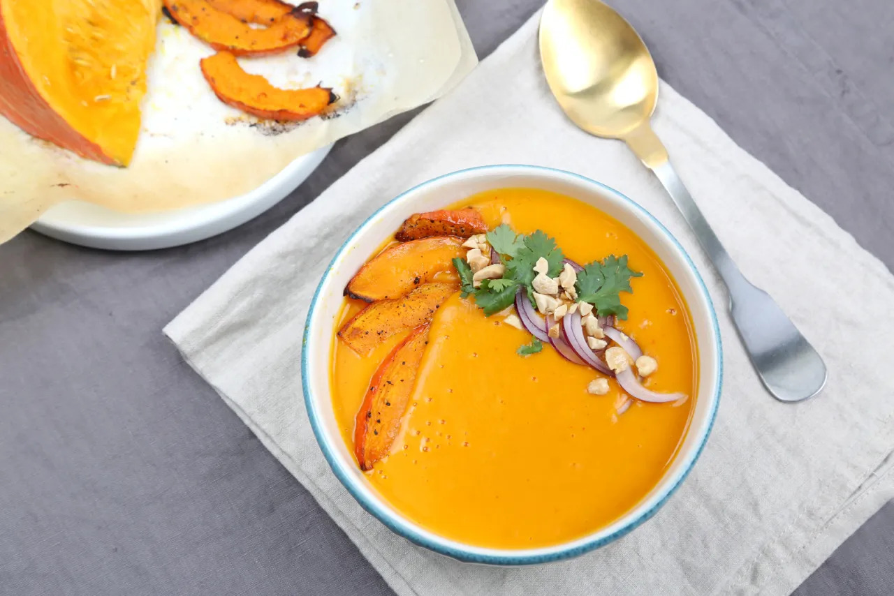 Aksamitna zupa z dyni wlasciwosci odżywcze. Podana z pieczoną dynią, orzeszkami i czerwoną cebulą.