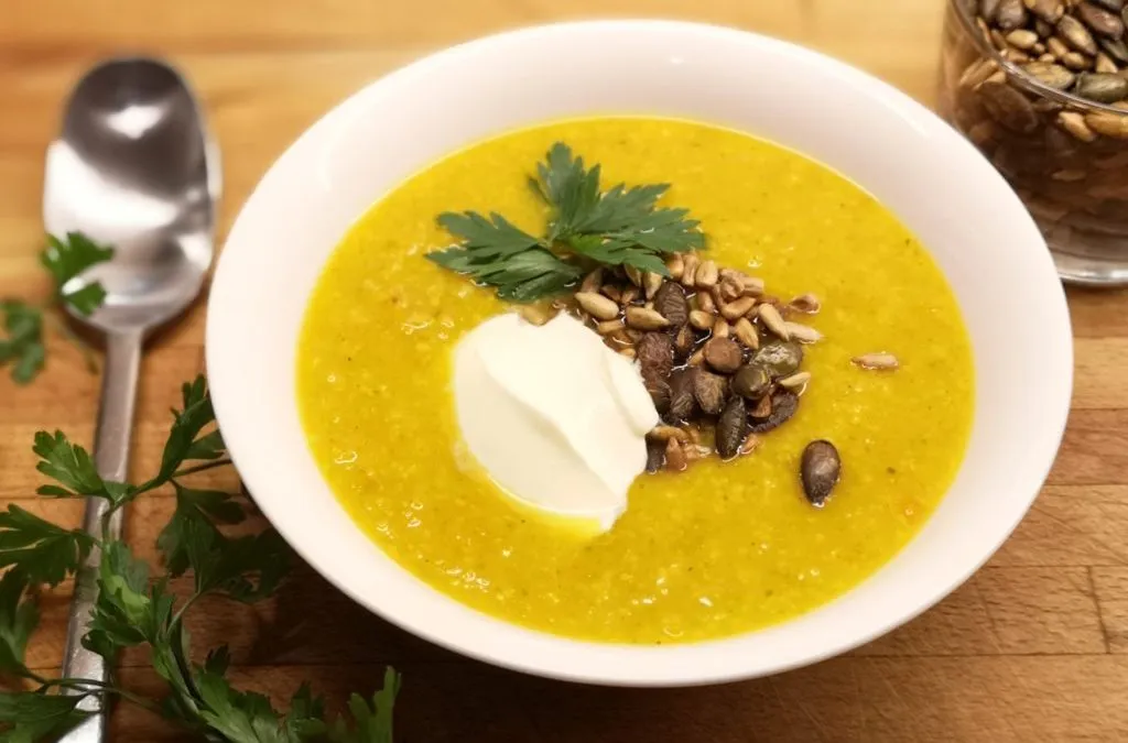 Zupa dyniowa udekorowana pestkami dyni i świeżą kolendrą