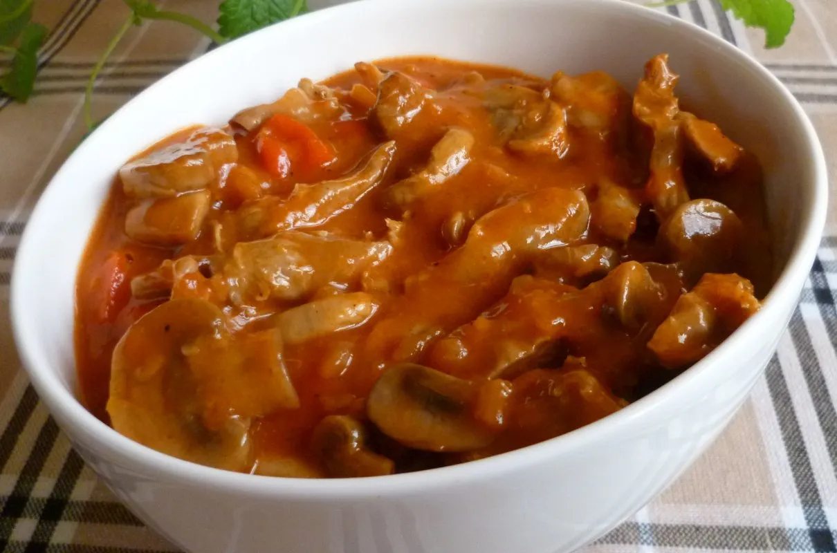 Gulasz z żołądków drobiowych, bogaty w pieczarki i marchewkę, w gęstym sosie. Bardzo dobry przepis na sycące danie.