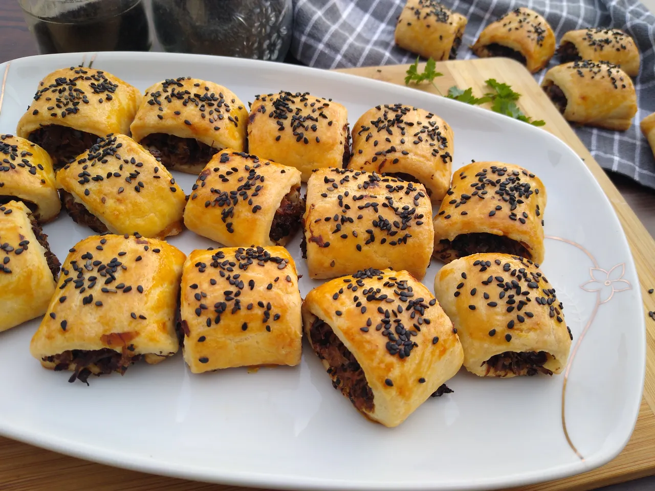 Paszteciki z kruchego ciasta, posypane czarnym sezamem, gotowe do podania. Idealne na przekąskę, zgodnie z przepisem na kruche ciasto na paszteciki.