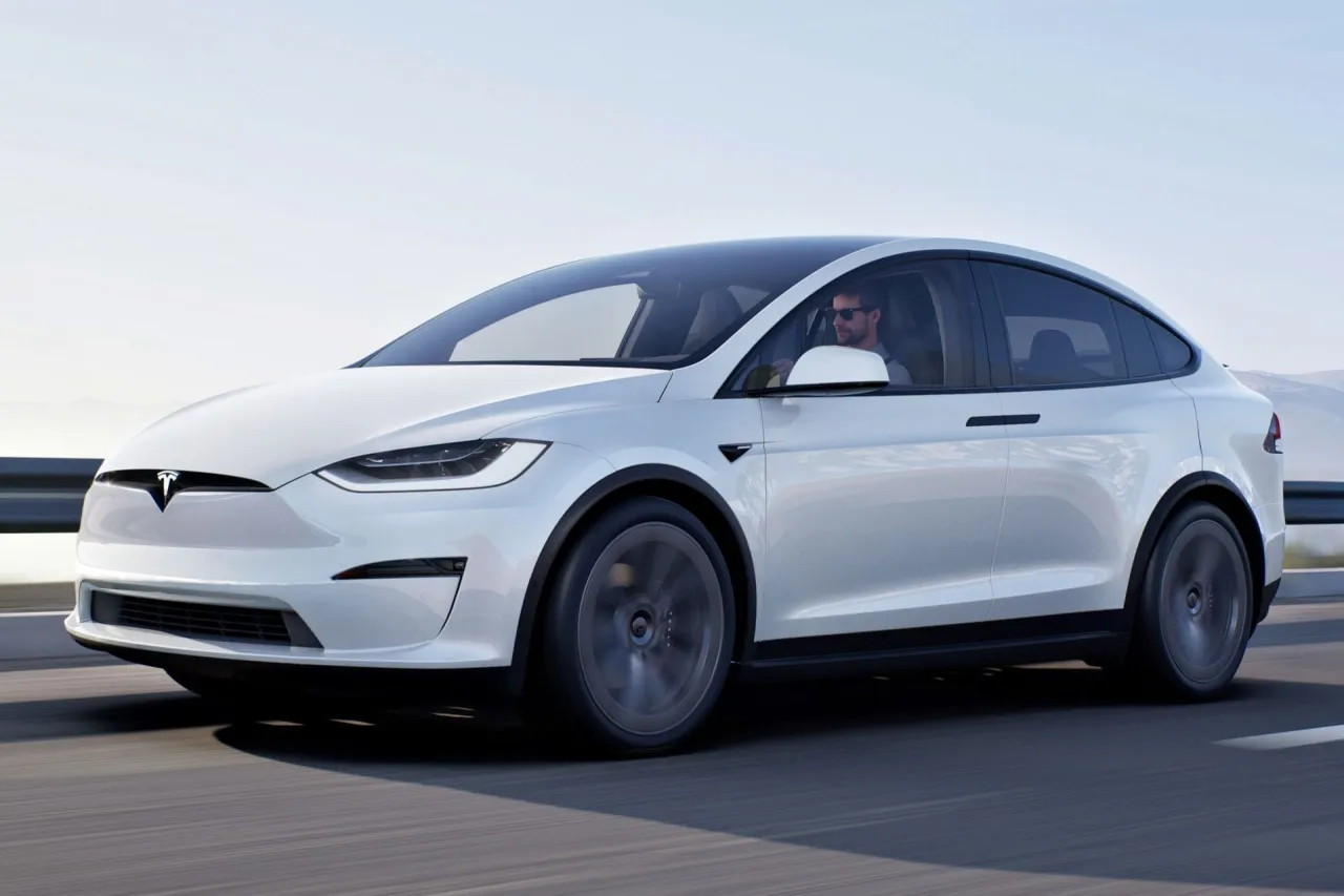 Biała Tesla Model X jedzie po drodze. Zastanawiasz się, ile kosztuje Tesla Model X?