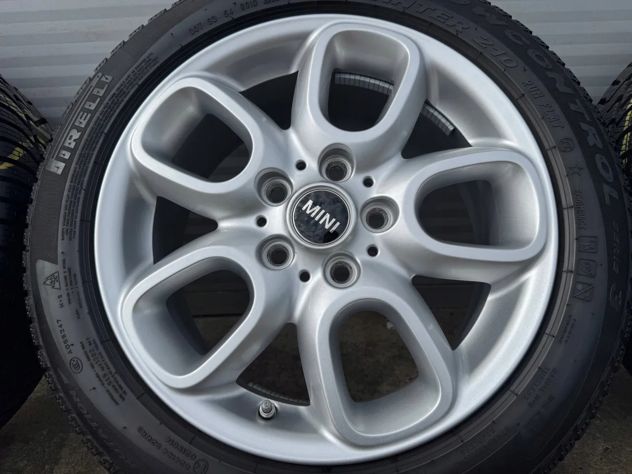 Srebrna felga z logo MINI. Wiele Mini Cooper&oacute;w nie ma tradycyjnego koła zapasowego, ale zestaw naprawczy.