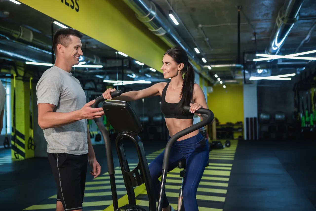 Para ćwiczy na orbitreku, czerpiąc korzyści z treningu cardio.