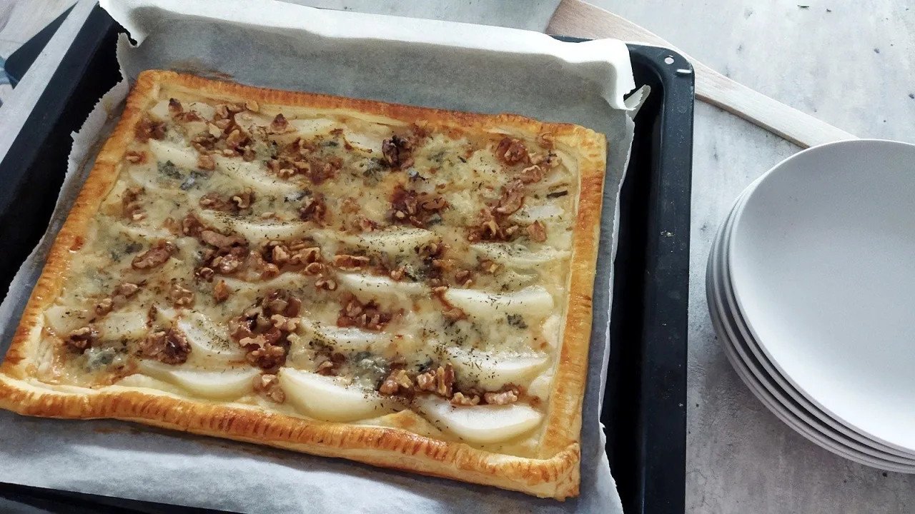 Pyszne ciasto francuskie z gruszkami i gorgonzolą, posypane orzechami włoskimi, gotowe do podania.