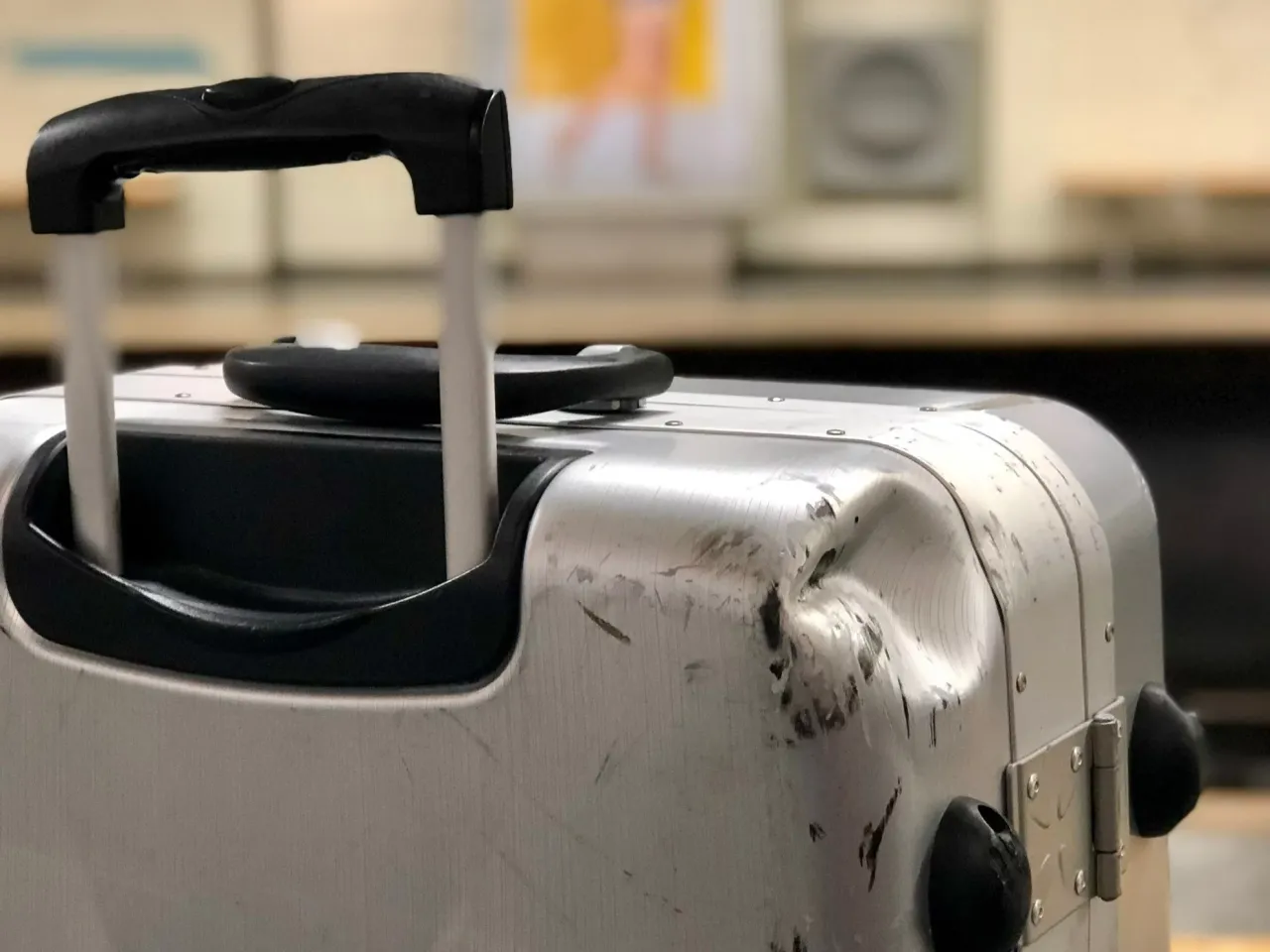 Uszkodzona walizka na lotnisku, bagaż po podróży