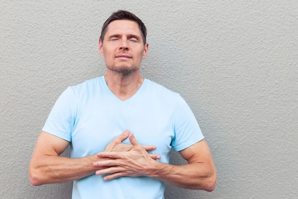 osoba trzymająca się za klatkę piersiową lęk b&oacute;l