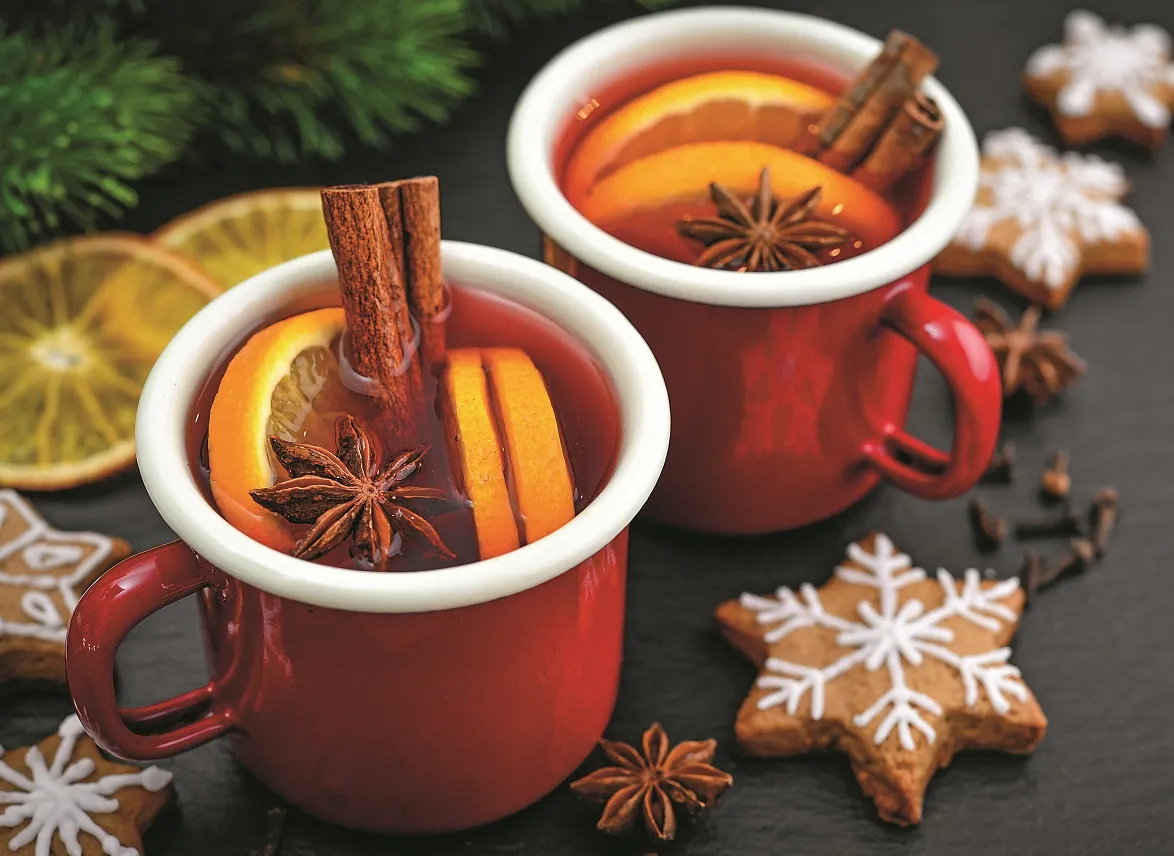 grzane wino w kubku z przyprawami i pomarańczą