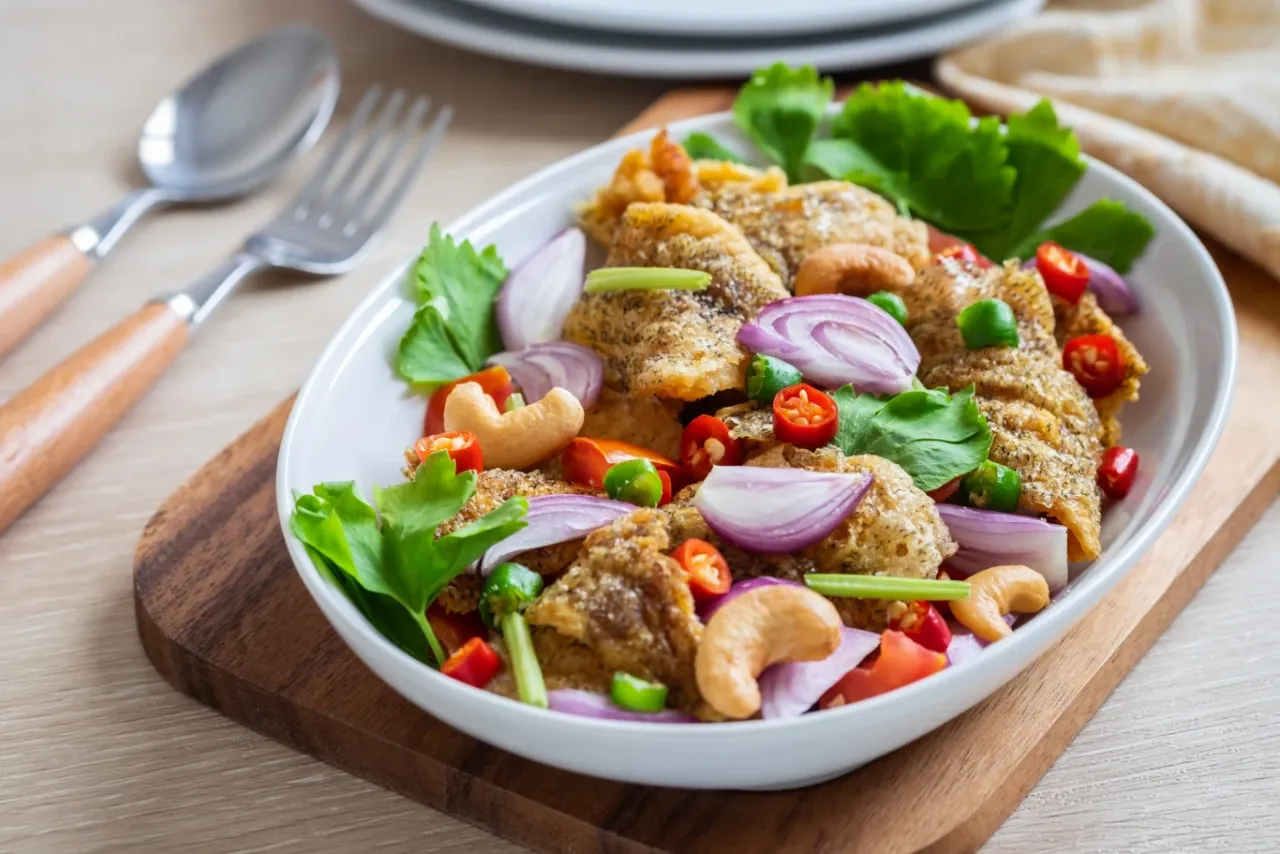 Chrupiąca ryba po tajsku z orzechami nerkowca, czerwoną cebulą i papryczkami chili.