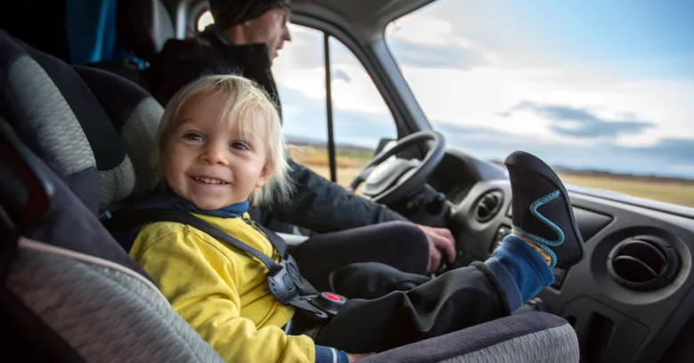 dziecko w foteliku na przednim siedzeniu samochodu