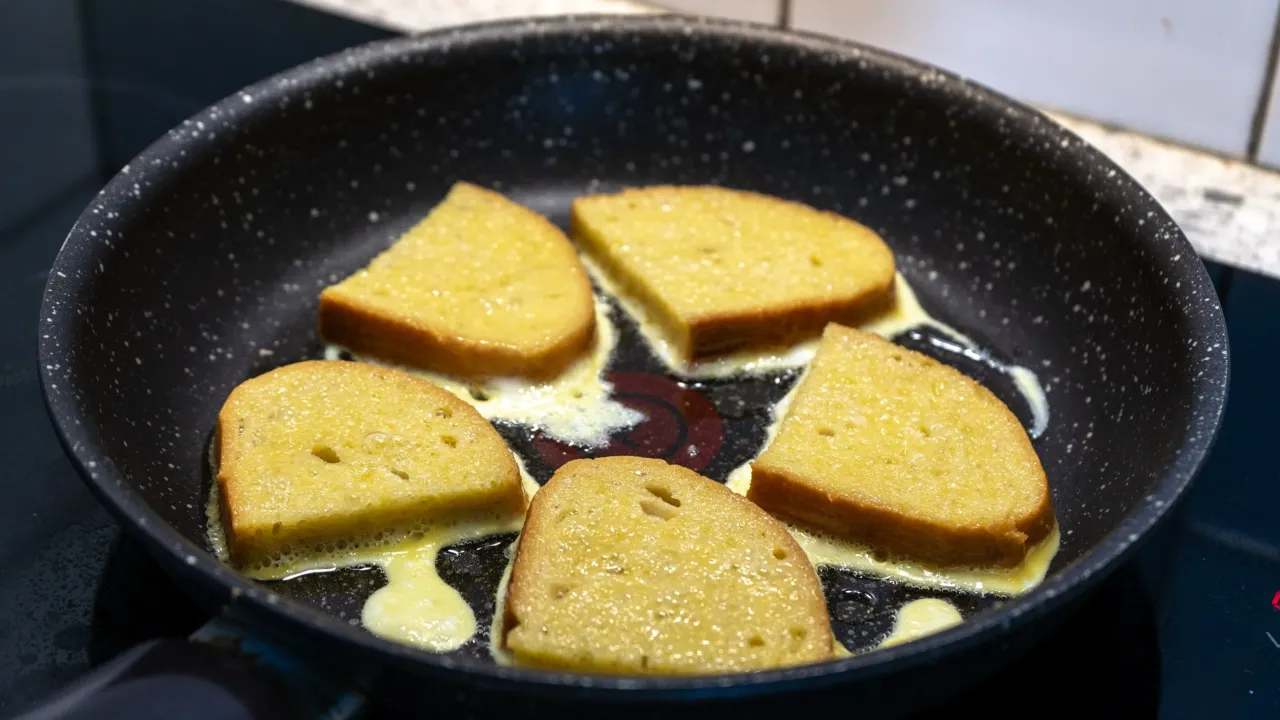 Smażone kromki chleba w jajku na patelni. Idealny spos&oacute;b, jak zrobić chleb w jajku na śniadanie.