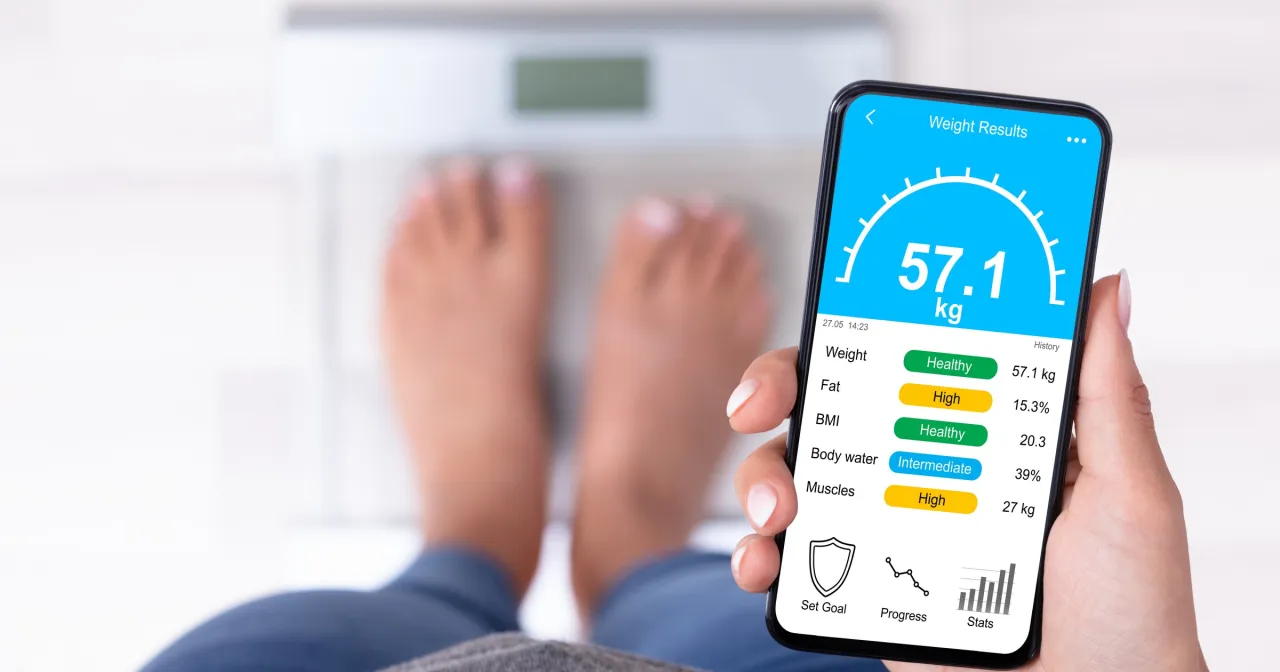 Kobieta mierząca się, zadowolona z efekt&oacute;w