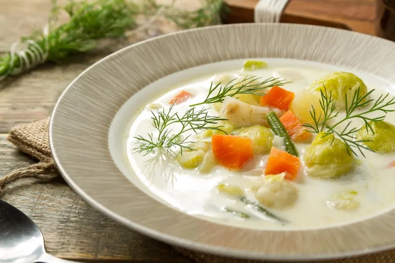 różne składniki zupy jarzynowej, warzywa, mięso, śmietana