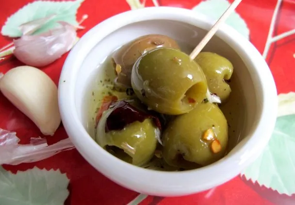 Oliwki w miseczce z ziołami i oliwą