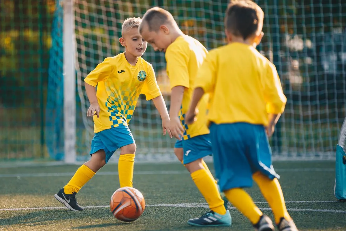 dzieci grające w piłkę nożną radość