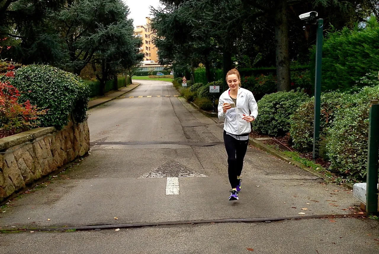 kobieta biegnąca w spokojnym tempie po płaskim terenie