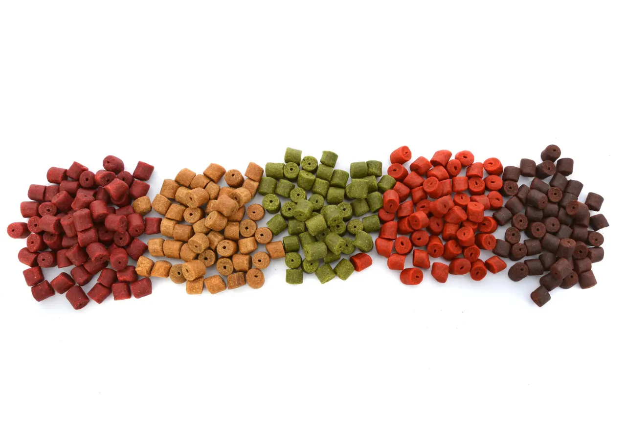 Pięć rzęd&oacute;w kolorowego pelletu na haczyk: czerwony, brązowy, zielony, pomarańczowy i ciemnobrązowy.