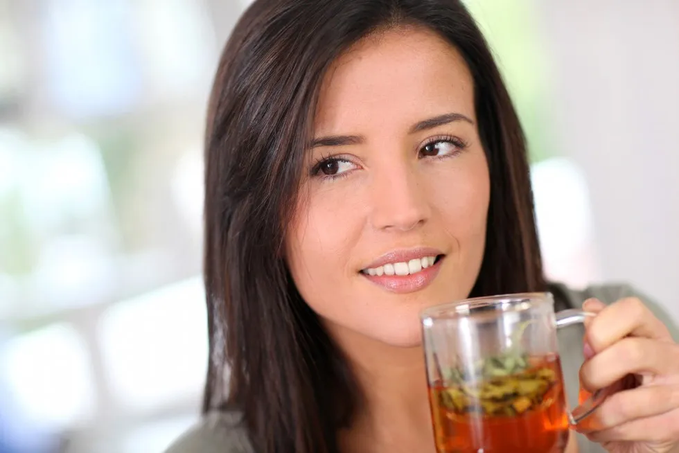 kobieta pije ziołową herbatę z ostrożnością