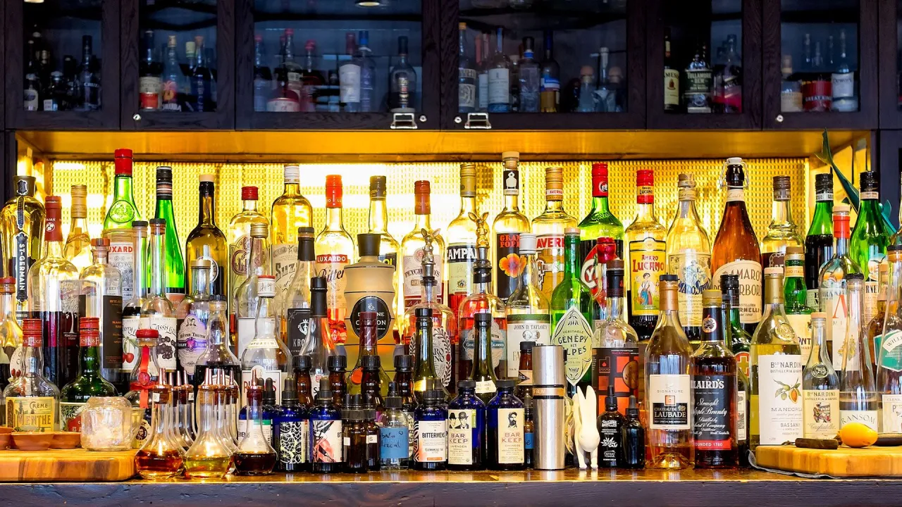 Rząd butelek z alkoholem, od likier&oacute;w po mocniejsze trunki. Czy na lotnisku można pić alkohol? Tutaj na pewno!