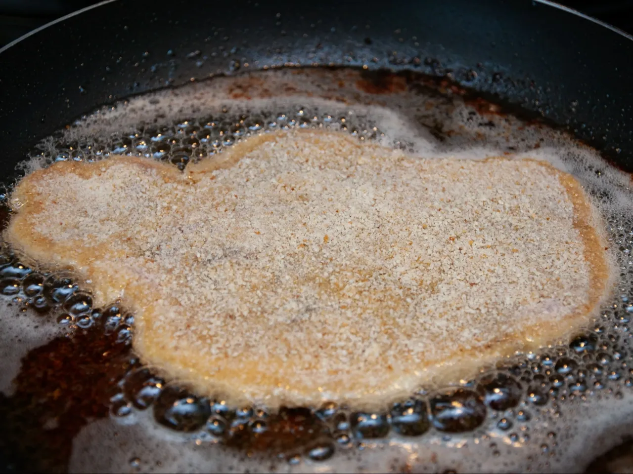 Schabowy smażony na smalcu i oleju roślinnym, otoczony bulgoczącym tłuszczem, nabiera apetycznego koloru.