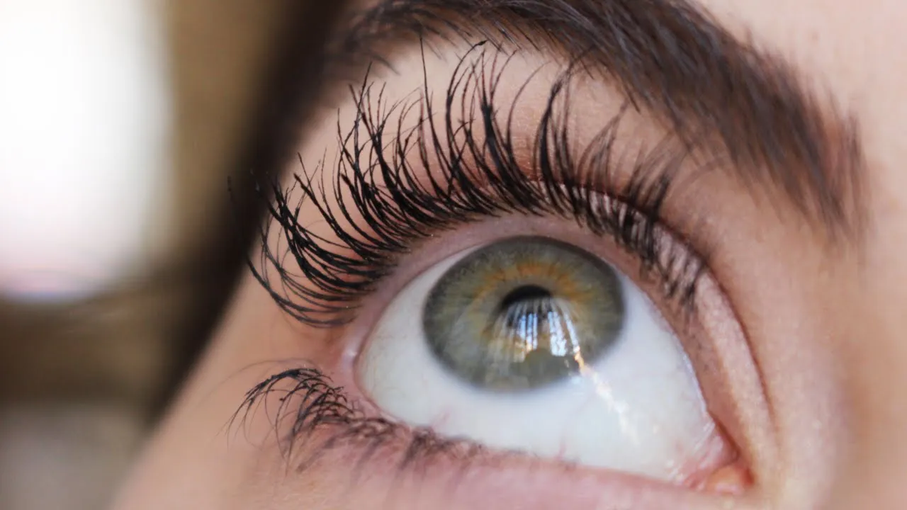 Kobieta aplikująca odżywkę na rzęsy