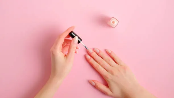 kobieta nakładająca krem do rąk i paznokci