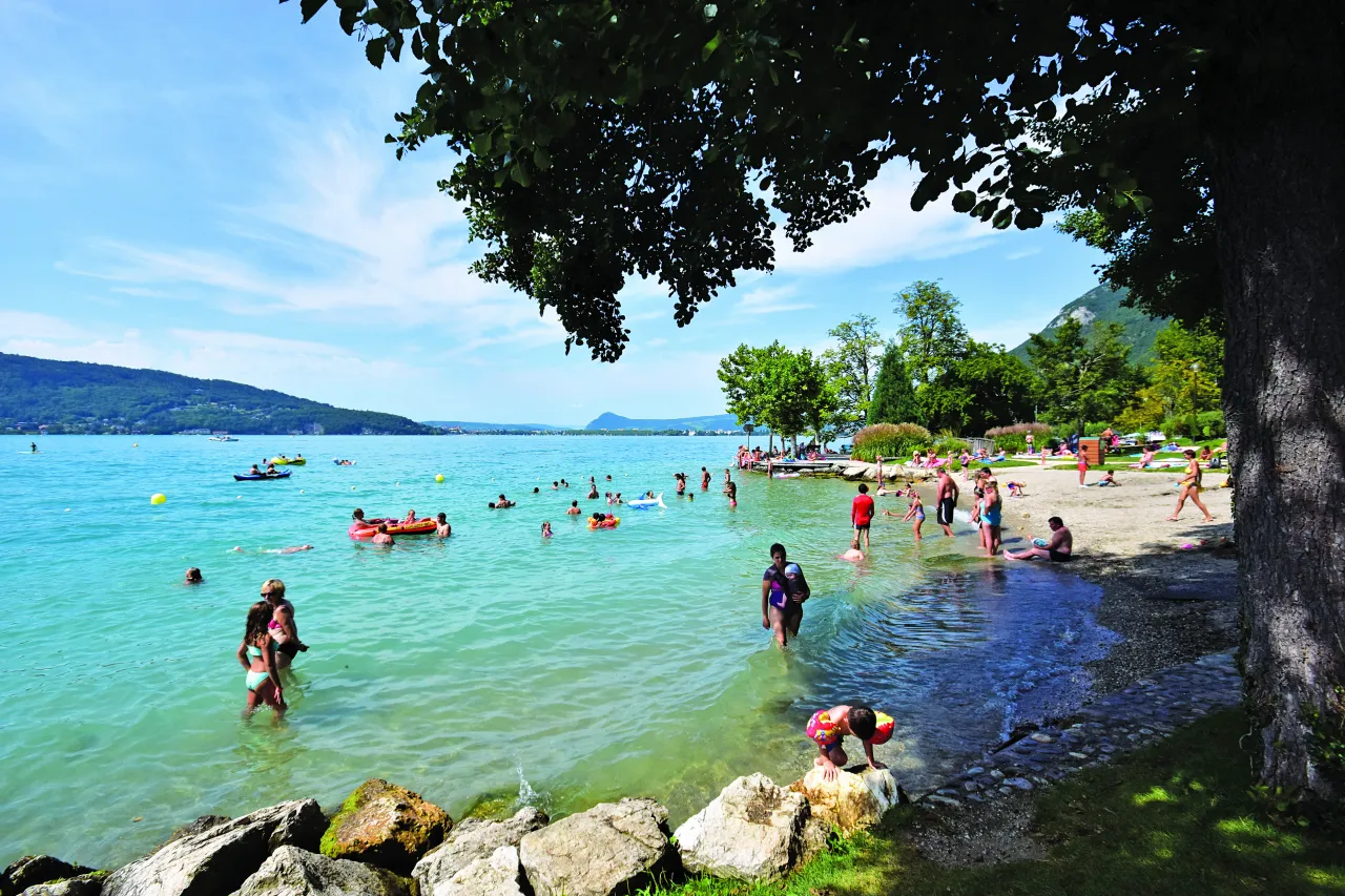 Ludzie kąpią się i pływają na jeziorze, ciesząc się słońcem. To jedno z najpiękniejszych miejsc we Francji.