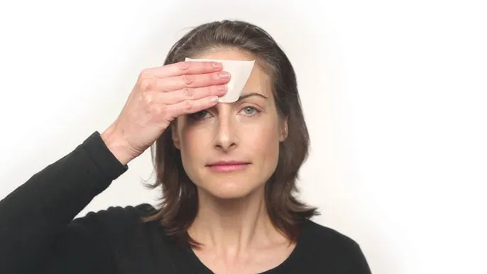 kobieta wykonująca test z bibułką na twarzy