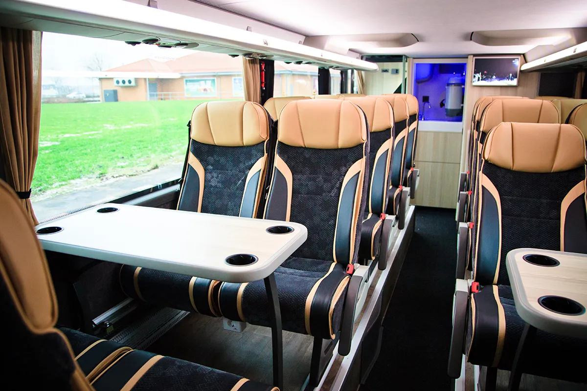 Wnętrze autokaru lux z dużą przestrzenią na nogi i wygodnymi fotelami