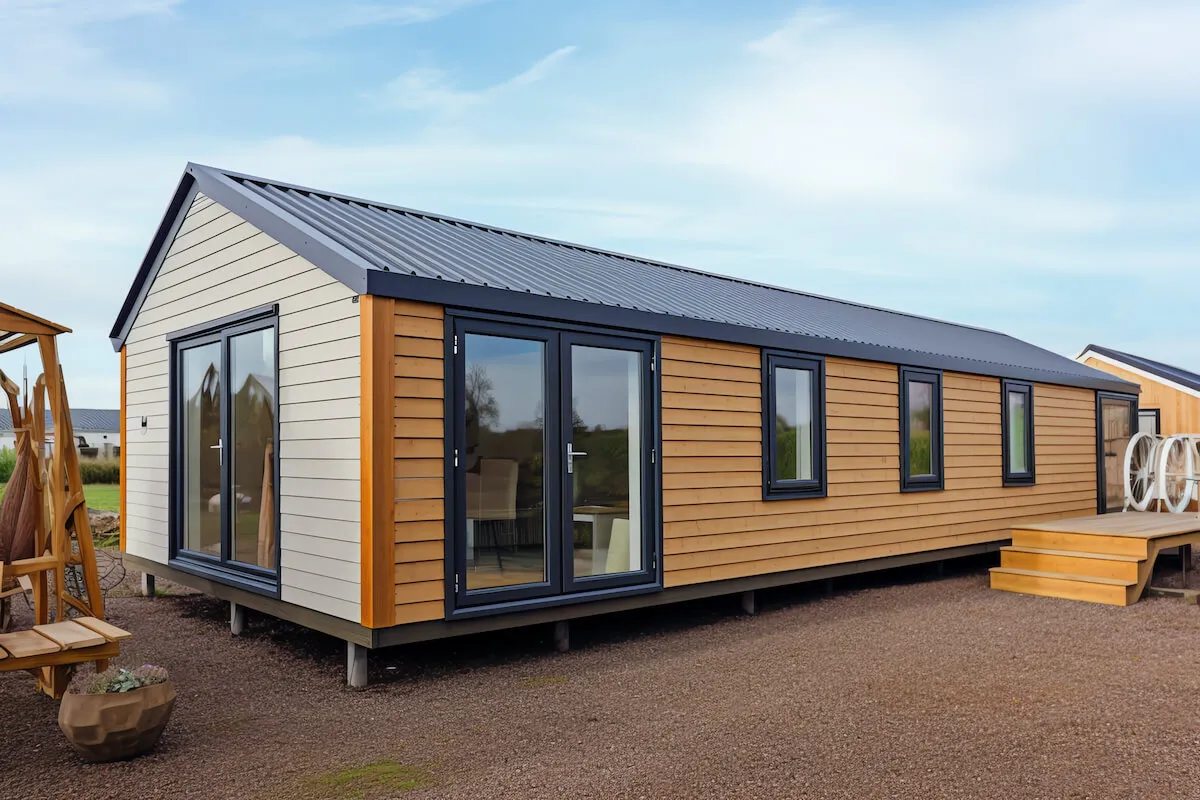 Nowoczesny dom modułowy z drewnianą elewacją i dużymi oknami. Zastanawiasz się, czy na dom modułowy potrzebne jest zezwolenie?