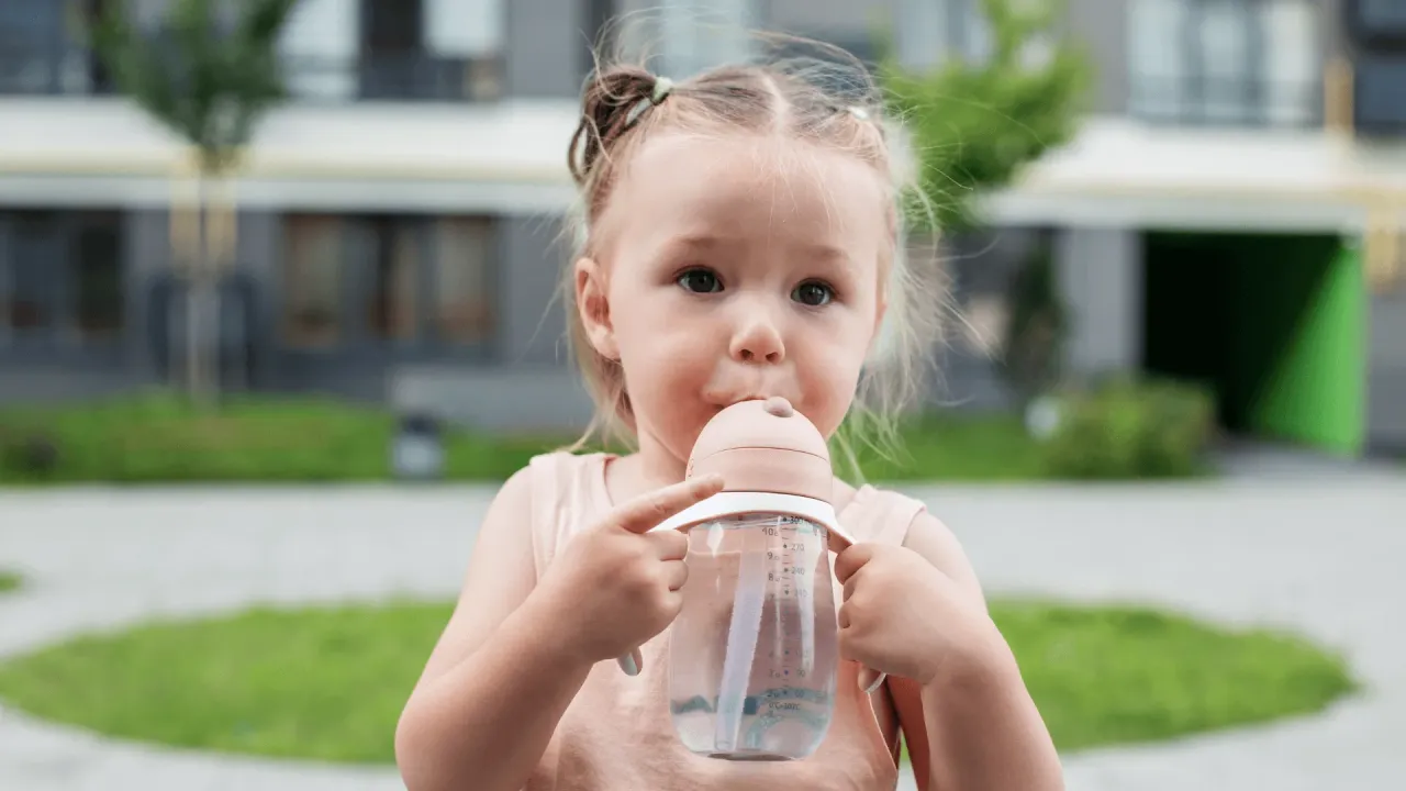 dziecko pije z butelki i kubka