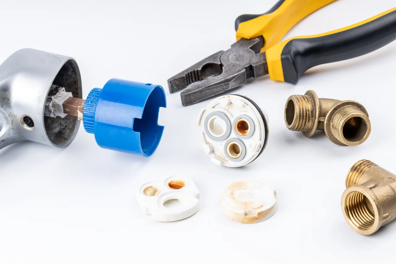 Narzędzia i części do kranu, w tym głowica, klucz i złączki. Dowiedz się, jak wymienić głowicę w kranie.