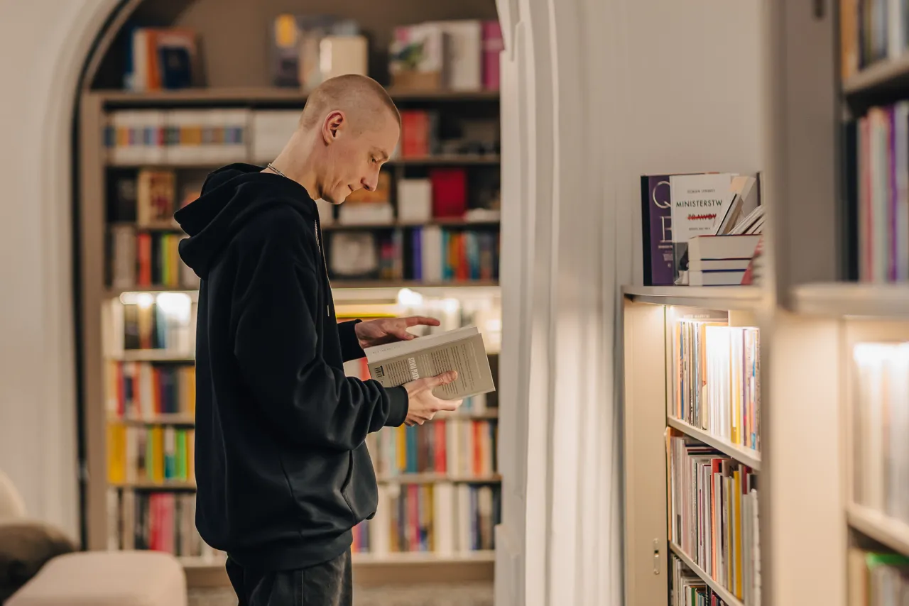 osoba wybierająca książkę w księgarni