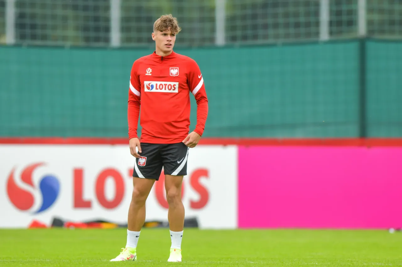 Młody piłkarz w stroju reprezentacji Polski, z logo LOTOS. Jego wiek to 22 lata.