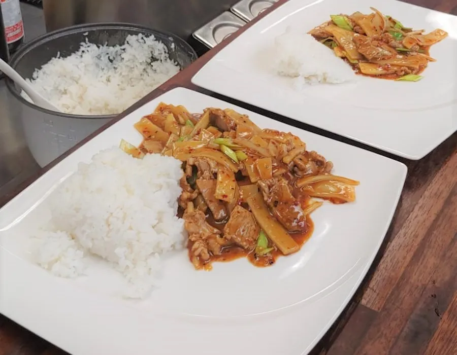 wieprzowina stir-fry z ryżem i warzywami na talerzu